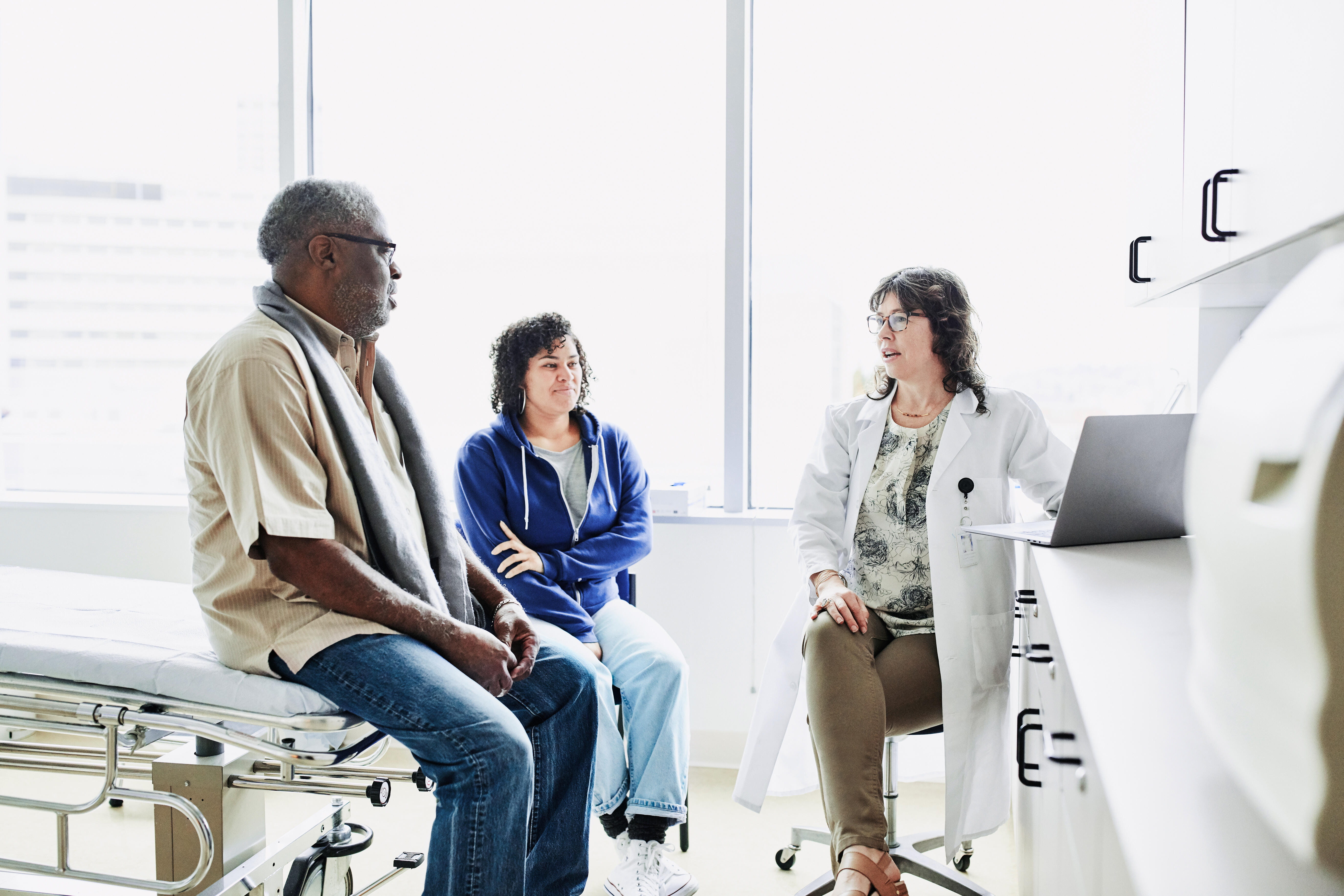 Doc with pt and caregiver_GettyImages-1211642633_RGB_Large_JPG (1)